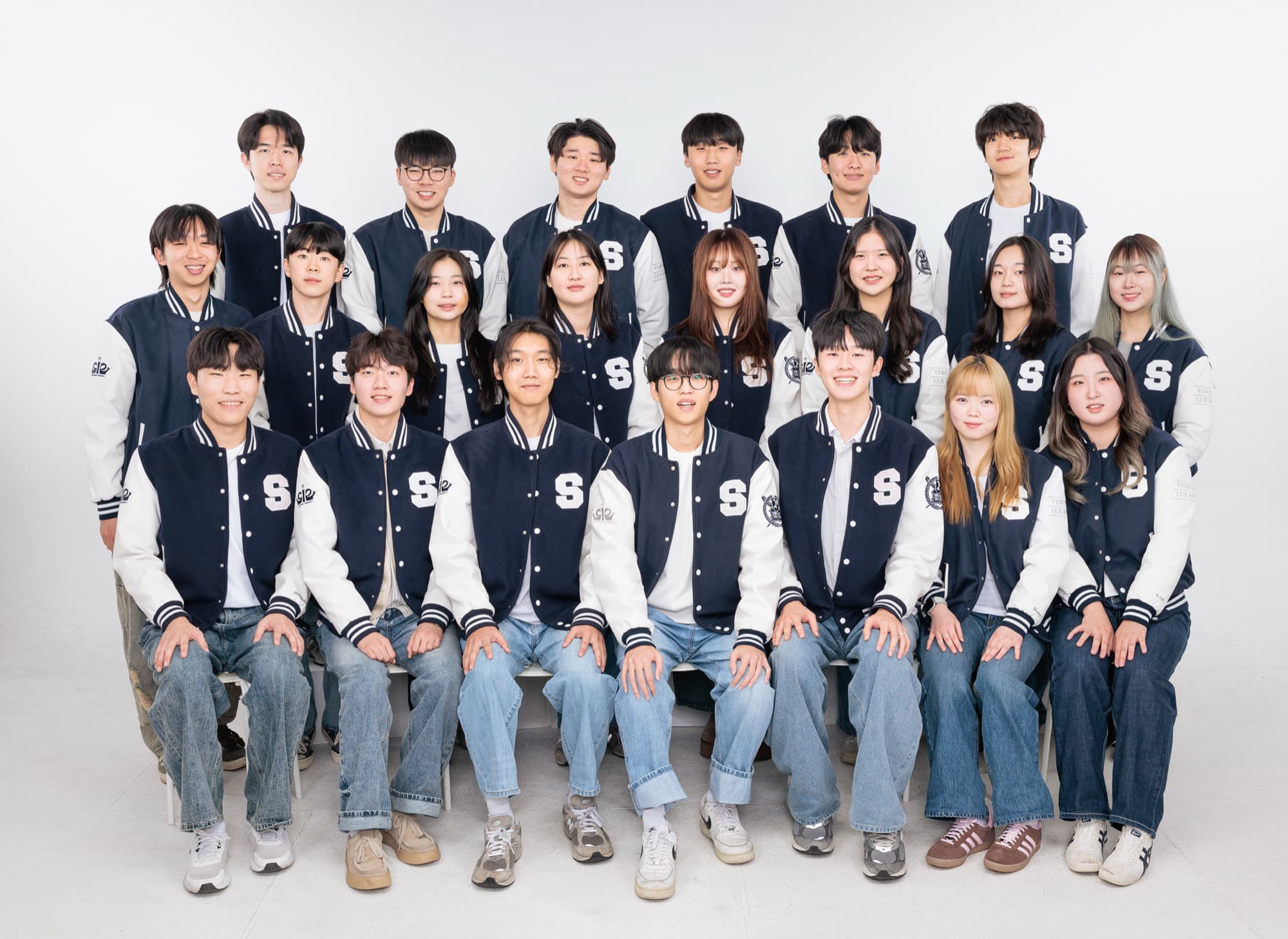 The SNU IE Student Council team in matching navy-and-white varsity jackets, posing for a formal studio group portrait.